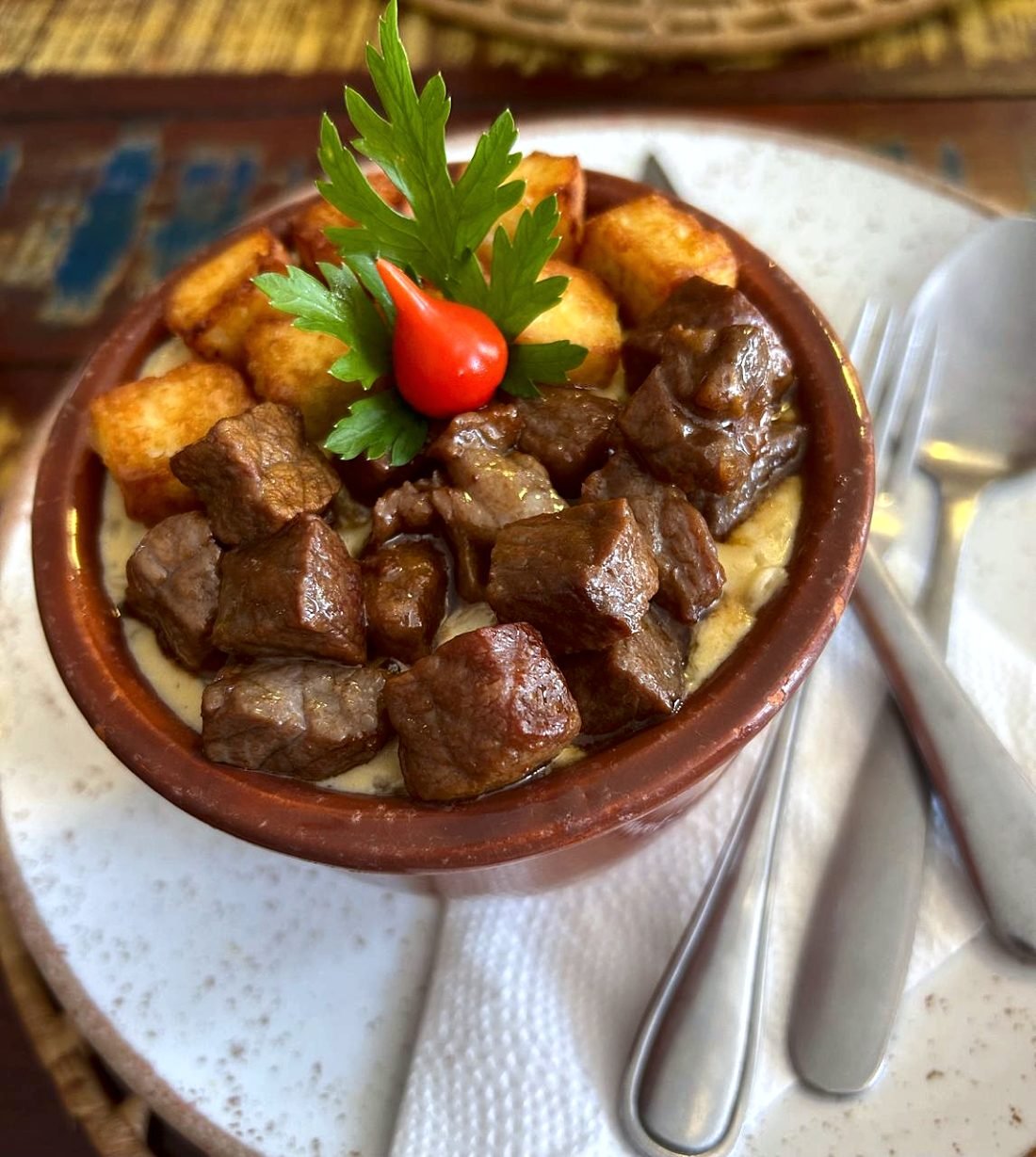 Rubacão servido na panelinha de barro: carne de sol em cubos, queijo coalho dourado e salsinha